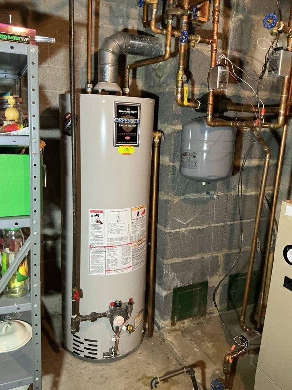 Performed scheduled boiler tune-up on residential system that was previously rescheduled. Equipment age undetermined due to multiple overlapping tags. System includes water heater with connected expansion tank and extensive copper piping network with multiple shutoff valves. No mechanical violations present. Completed standard preventative maintenance procedures and verified proper operation.