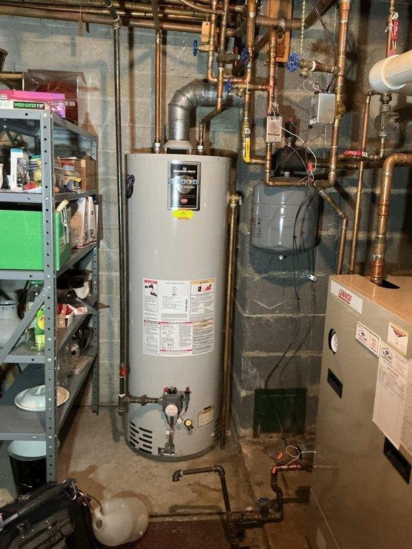 Performed scheduled boiler tune-up on residential system that was previously rescheduled. Equipment age undetermined due to multiple overlapping tags. System includes water heater with connected expansion tank and extensive copper piping network with multiple shutoff valves. No mechanical violations present. Completed standard preventative maintenance procedures and verified proper operation.