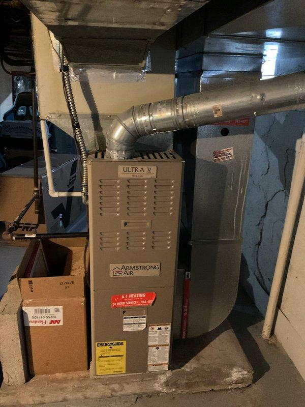 Completed estimate for replacement of an Armstrong Air "Ultra V" furnace currently installed in basement utility area. Existing unit shows normal wear with complete ductwork system including metal elbow connections and proper ventilation. Proposal includes removal of current equipment and installation of new compatible furnace with all necessary connections to existing ductwork, gas, and condensate drain systems.