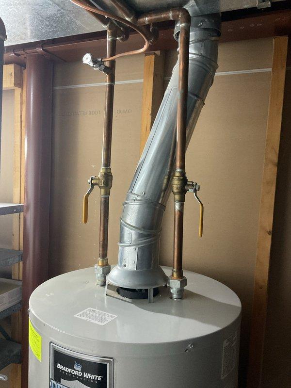 Conducted site assessment and photographed existing Bradford White water heater installation in basement utility area for replacement quote. Documented current configuration including copper supply lines, vent piping, and connection points to assist with accurate equipment sizing and installation planning.