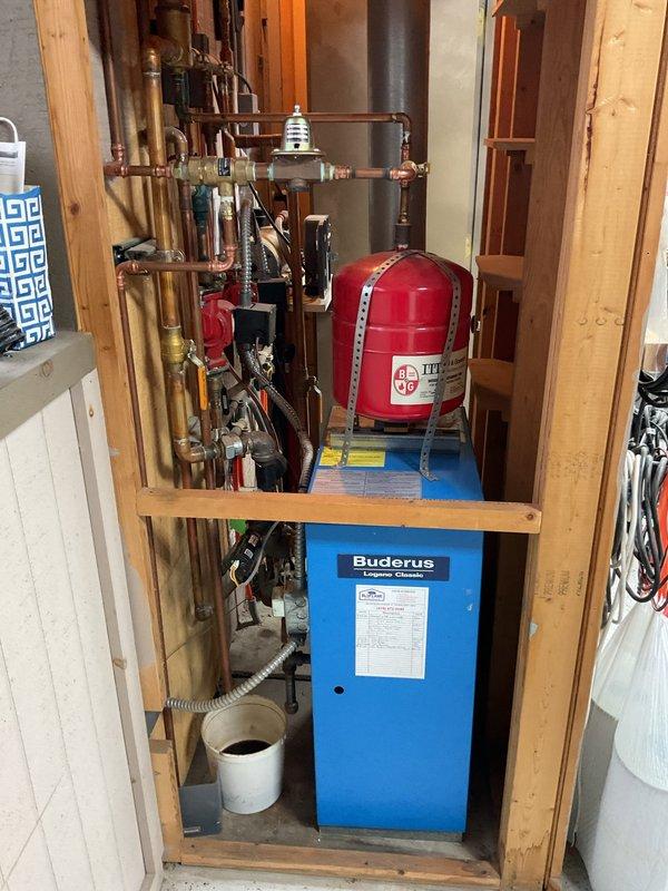 Completed comprehensive boiler estimate for Buderus heating system installation. Assessment included evaluation of existing copper piping network, expansion tank, pressure regulator, and ventilation components. Photos documented current system configuration in mechanical room to support detailed replacement proposal.