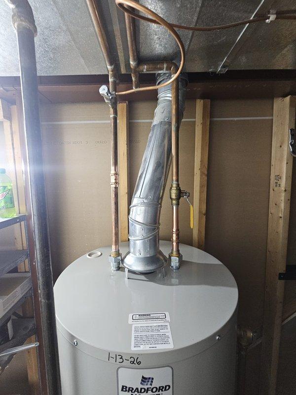 Successfully installed a 50-gallon Bradford natural gas, natural draft water heater in utility room. Connected copper supply lines and properly vented with metal flue pipe to existing ductwork. Drained old tank using 20ft hose into bathroom.