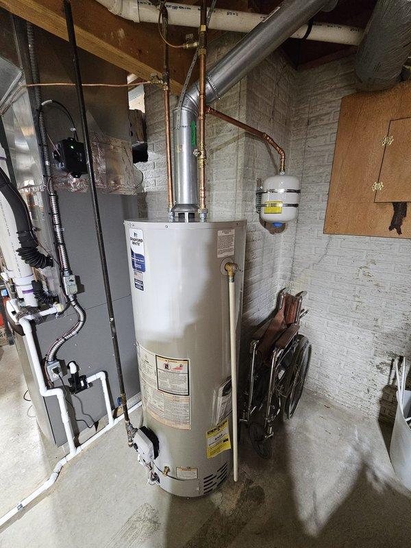 Successfully installed a 50-gallon natural draft water heater in basement utility area, reusing the existing expansion tank. System was properly connected to existing copper pipes and ventilation, with all connections tested for proper function.