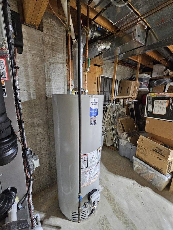 Successfully installed a 50-gallon natural draft water heater in basement utility area, reusing the existing expansion tank. System was properly connected to existing copper pipes and ventilation, with all connections tested for proper function.
