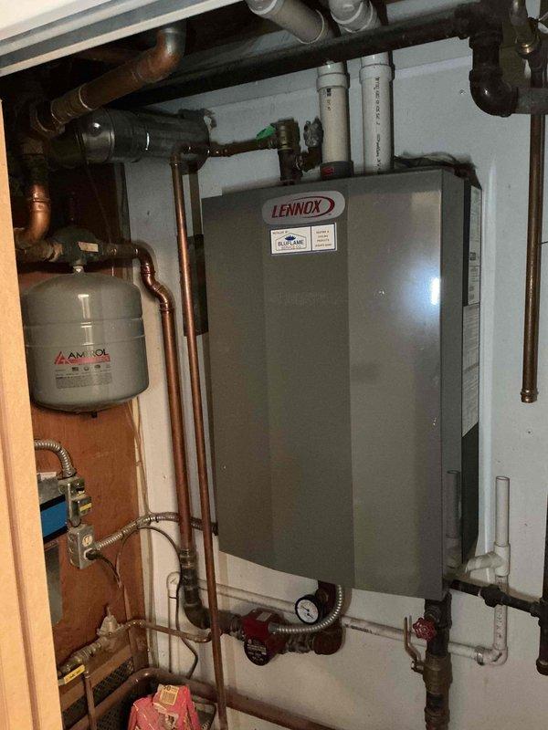 Performed scheduled furnace tune-up on Lennox heating system. Inspected complete heating assembly including expansion tank, pressure gauge, and associated copper/PVC piping. Noted significant corrosion on copper elbow joint near brass valve assembly requiring future attention. System currently operational with no immediate safety concerns.