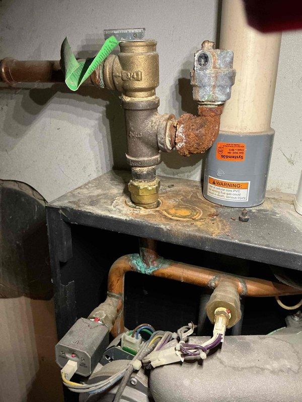 Performed scheduled furnace tune-up on Lennox heating system. Inspected complete heating assembly including expansion tank, pressure gauge, and associated copper/PVC piping. Noted significant corrosion on copper elbow joint near brass valve assembly requiring future attention. System currently operational with no immediate safety concerns.