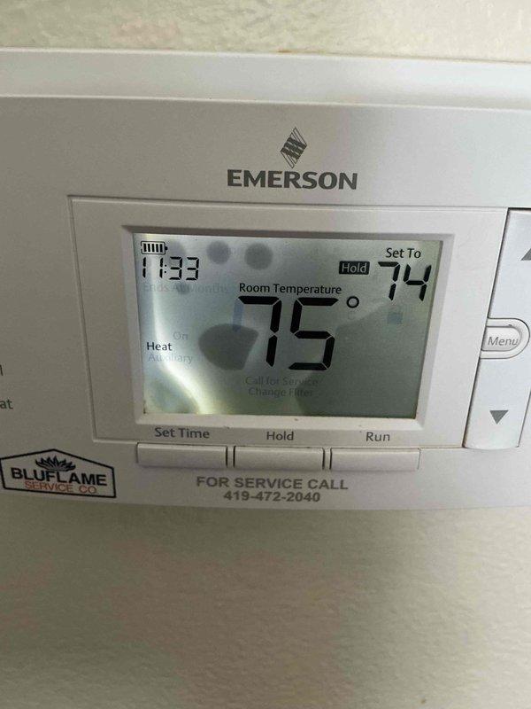 Responded to customer complaint regarding thermostat malfunction after customer inadvertently disrupted settings. Diagnosed Emerson thermostat displaying error codes, reset system parameters and confirmed proper operation. Verified heating system now functioning correctly with heat mode active and temperature properly calibrated at 74°F setpoint.