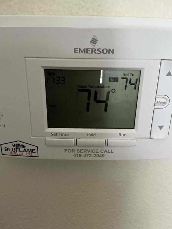 Responded to customer complaint regarding thermostat malfunction after customer inadvertently disrupted settings. Diagnosed Emerson thermostat displaying error codes, reset system parameters and confirmed proper operation. Verified heating system now functioning correctly with heat mode active and temperature properly calibrated at 74°F setpoint.