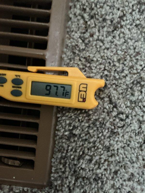 Performed diagnostic temperature testing on heating system, measuring supply air temperature at 97.7°F while return air registered at 72.8°F, confirming proper temperature differential of approximately 25°F. Noted significant dust accumulation on vent registers requiring cleaning to maintain optimal airflow and system efficiency.