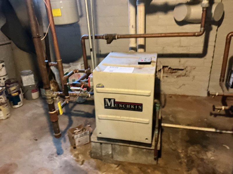 Performed inspection of Munchkin boiler system in basement utility room. Examined copper piping network, connections, valves, and expansion tank for proper installation and functionality. System appears operational with no visible leaks or immediate concerns noted.