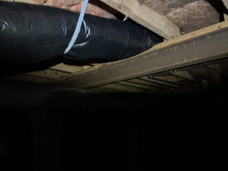 Replaced damaged flexible ductwork in crawl space, securing new insulated black flex ducts with appropriate fasteners and sealing with metal tape. Installed vapor barrier and added pink fiberglass insulation between joists to improve system efficiency and prevent heat loss.