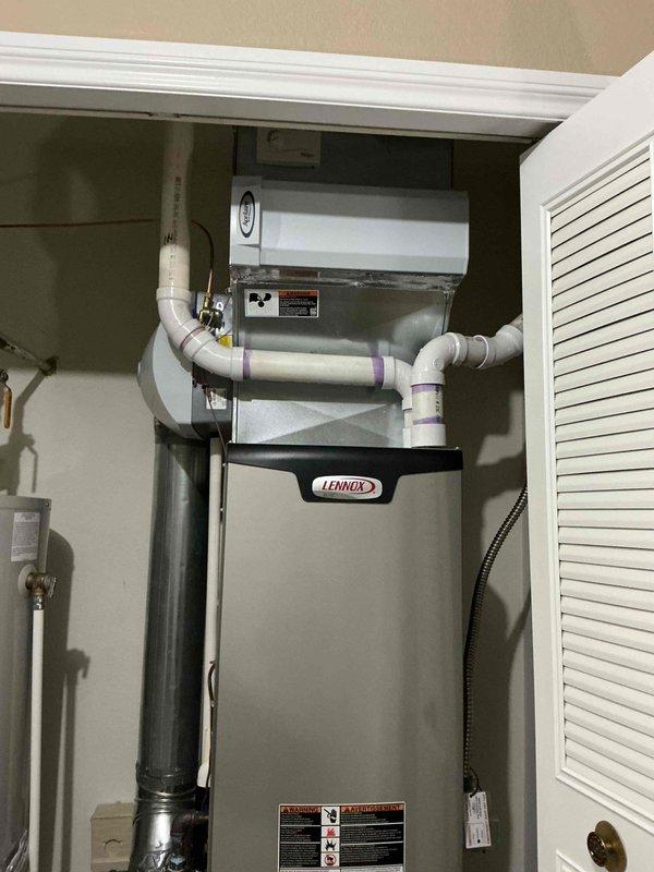 Performed scheduled furnace maintenance on Lennox HVAC system. Inspected installation where customer reported misaligned holes compared to previous unit. Verified all connections, ventilation system (including PVC pipes with purple markings at joints), and proximity to water heater were within code requirements and functioning properly.