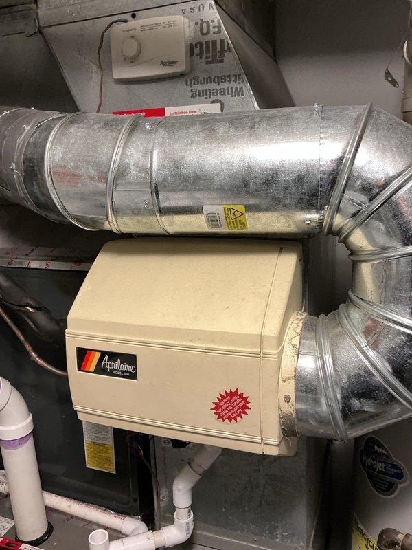 Performed scheduled furnace tune-up service. Inspected and verified Aprilaire humidifier installation connected to the HVAC system. Examined air filter element showing normal wear; filter has metal mesh screen with diamond pattern. System includes proper ductwork connections and PVC drainage components.