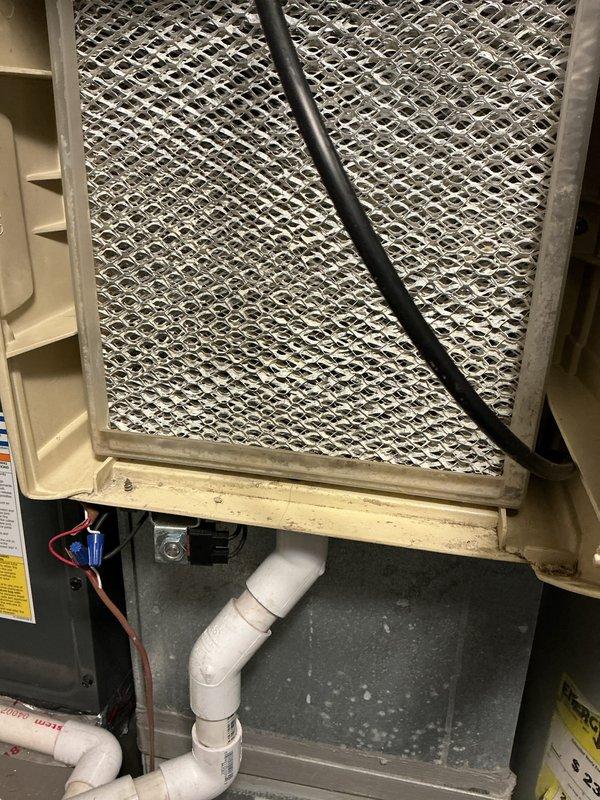 Performed scheduled furnace tune-up service. Inspected and verified Aprilaire humidifier installation connected to the HVAC system. Examined air filter element showing normal wear; filter has metal mesh screen with diamond pattern. System includes proper ductwork connections and PVC drainage components.