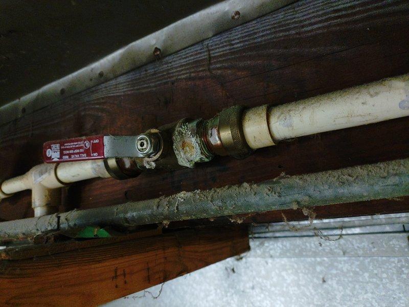 Responded to service call for water heater with inoperable pilot light. Inspection revealed significant corrosion and mineral buildup on brass fittings connected to water supply lines. Found severely corroded heat exchanger inside the tank with visible rust damage. Cleaned gas valve assembly and successfully relit pilot to restore hot water functionality.