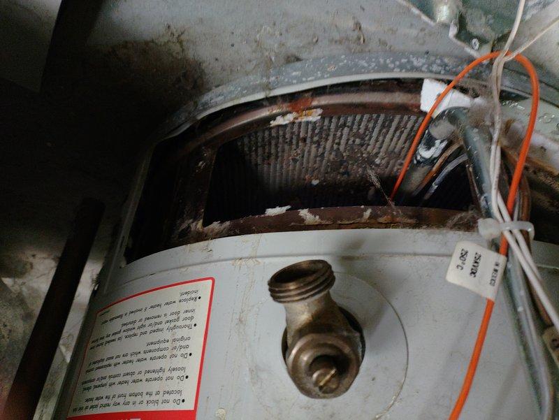 Responded to service call for water heater with inoperable pilot light. Inspection revealed significant corrosion and mineral buildup on brass fittings connected to water supply lines. Found severely corroded heat exchanger inside the tank with visible rust damage. Cleaned gas valve assembly and successfully relit pilot to restore hot water functionality.