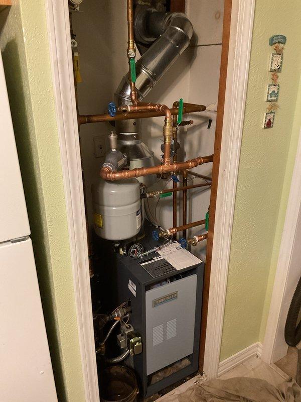 Successfully installed a new floor mount boiler system in the utility closet, complete with proper copper pipe connections, expansion tank mounting, and ventilation ducting. System was tested and confirmed to be in good working condition with no leaks.