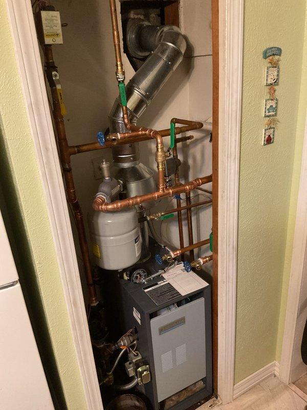 Successfully installed a new floor mount boiler system in the utility closet, complete with proper copper pipe connections, expansion tank mounting, and ventilation ducting. System was tested and confirmed to be in good working condition with no leaks.