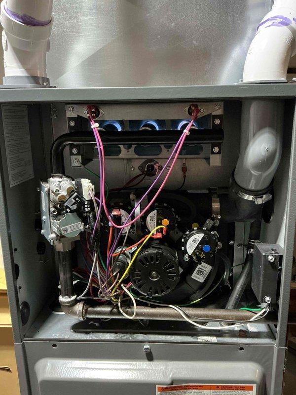 Responded to no-heat call for 3-year-old furnace with MVP warranty valid until 2025. Upon inspection of the interior components, found the furnace not operating due to a faulty blower motor, evidenced by the disconnected wiring. Replaced the defective motor assembly, reconnected all electrical components (pink, yellow, white, and green wires), and verified proper gas valve operation. System now functioning correctly with normal heating cycle restored.
