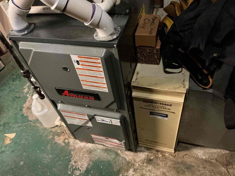 Performed routine maintenance on 10-year-old natural gas furnace. Inspected interior components including electrical connections, wiring, and control circuits. Examined Amana furnace unit with connected ventilation system and Space-Gard air cleaner, ensuring proper operation for the heating season.