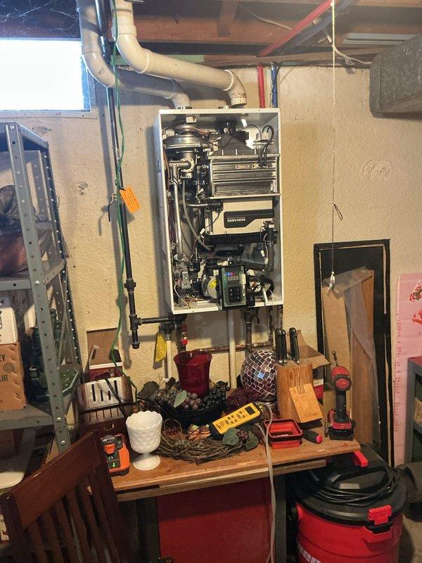 Responded to service call for tankless water heater displaying error code 89e-10 and non-operational status. Upon inspection, found excessive condensation on internal components affecting system operation. Removed front panel to access and diagnose internal systems, cleaned affected components, and reset error code. Unit now functioning properly with no error codes present.