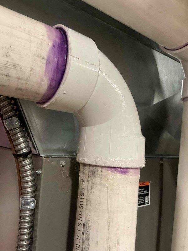 Responded to service call for 2-year-old furnace with reported leak. Inspection revealed condensate drain line issue with compromised PVC pipe connection (FS10-SD195). Resealed joint with PVC primer/cement and verified proper drainage. System now operating normally with no leaks detected.
