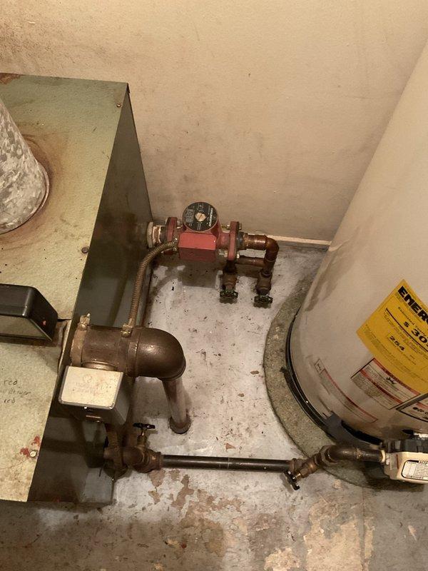 Performed comprehensive assessment of existing boiler system for replacement. Documented current installation consisting of Whirlpool water heater with circulation pump and associated copper piping network. Evaluated adjacent furnace/heating unit with connected galvanized ductwork to ensure proper integration with proposed new boiler system.