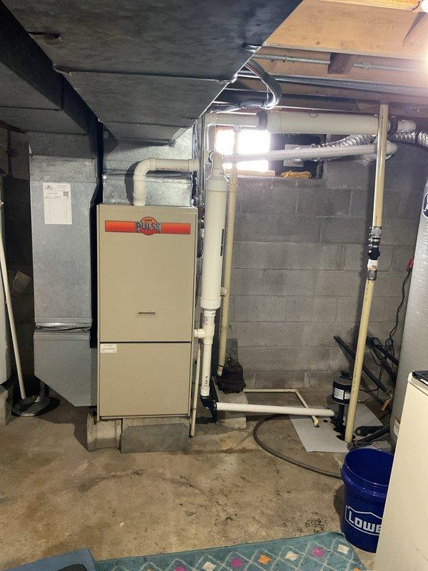 Performed on-site assessment for furnace replacement in unfinished basement. Current installation features beige furnace with associated PVC exhaust/intake pipes and metal ductwork. Evaluated existing ventilation system including flexible metallic ducts and PVC piping. Provided comprehensive replacement estimate based on inspection findings.
