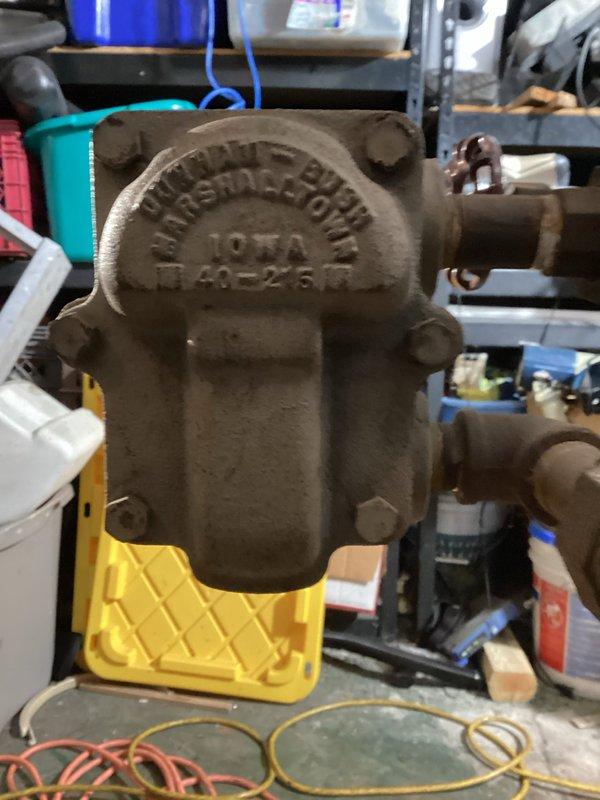 Initiated removal of existing steam gas boiler system as scheduled. Documented existing plumbing infrastructure including main valve assembly and pipe connections. Identified IOWA model E 40-2487 pump/valve component with protective drip tray for assessment during replacement process.