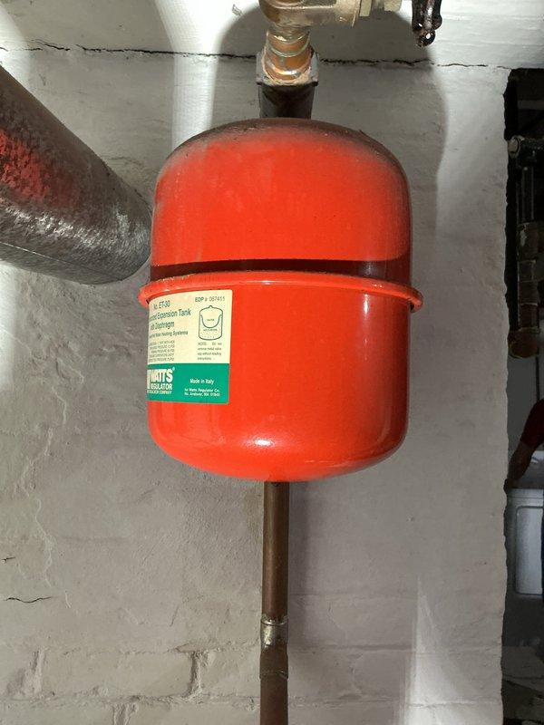 Performed inspection of furnace for property sale preparation. Observed aging plumbing infrastructure including a Watts expansion tank and cast iron piping showing signs of wear. System appears functional but displays normal aging in copper connections and potential corrosion on cast iron components.