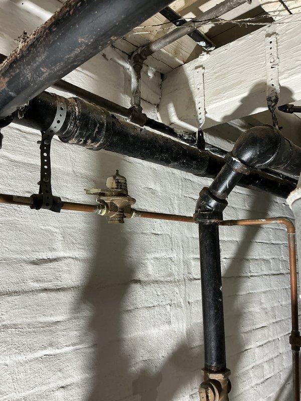 Performed inspection of furnace for property sale preparation. Observed aging plumbing infrastructure including a Watts expansion tank and cast iron piping showing signs of wear. System appears functional but displays normal aging in copper connections and potential corrosion on cast iron components.