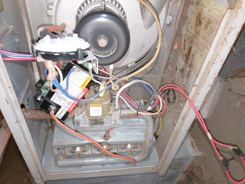Diagnosed and serviced 1969 Hotpoint furnace with ignition failure. Inspected control board connections and gas burner assembly which showed significant corrosion and wear. Repaired electrical connections and cleaned oxidized components in the blower motor assembly. System now ignites properly with all functions restored to working condition.