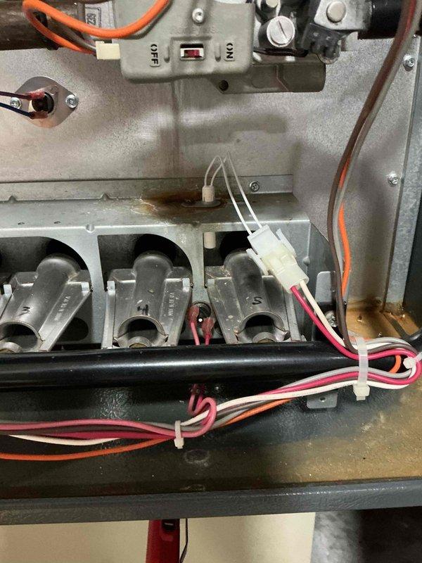 Performed routine maintenance on 11-year-old natural gas furnace. Inspected igniter and control assembly, noting some rust staining on heat exchanger surfaces. System operational with igniter and gas valve functioning correctly.