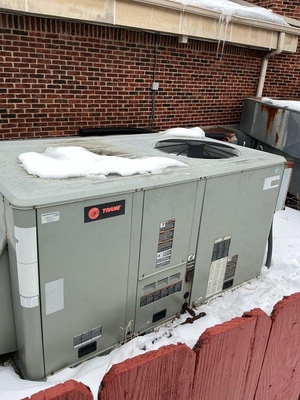 Responded to no heat call for Trane furnace. Discovered significant snow and ice accumulation on rooftop unit causing restricted airflow. Cleared snow from unit, inspected for rust damage on housing panels, and verified proper operation after servicing. Unit returned to normal functioning with proper heating output.