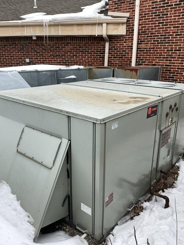 Responded to no heat call for Trane furnace. Discovered significant snow and ice accumulation on rooftop unit causing restricted airflow. Cleared snow from unit, inspected for rust damage on housing panels, and verified proper operation after servicing. Unit returned to normal functioning with proper heating output.
