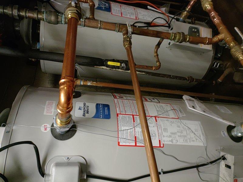 Diagnosed issue with Bradford White tanked water heater system. Identified faulty actuator affecting proper operation. Inspected dual-tank installation with copper piping network and examined connections for signs of water damage. Repaired actuator to restore normal functionality.