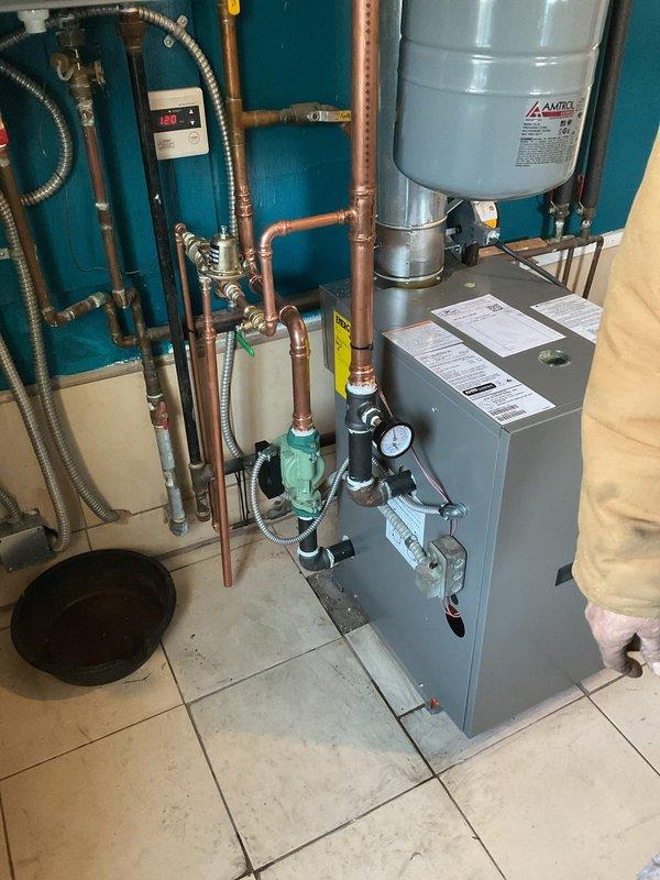 Successfully installed new Lennox 120kbtu floor mount boiler with reused circulation pump and new zone valves. System was properly connected to existing copper piping network and includes an Amtrol expansion tank. Verified proper operation with thermostat set at 65°F.