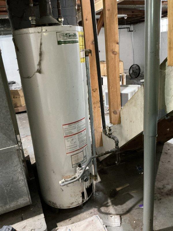 Performed diagnostic assessment on an aging A.O. Smith tank water heater showing significant corrosion and mineral buildup around top connection points. Identified and addressed issues with copper and brass pipe connections, focusing on the deteriorated areas at the tank's top where mineral deposits had accumulated. Restored proper functionality to the system, ensuring safe and efficient operation.