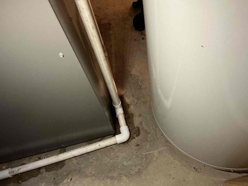 Diagnosed 1-year-old natural gas furnace with water leakage. Inspection revealed condensate drainage issues with visible water staining at the base of the unit. Cleared blocked condensate line and verified proper drainage function to resolve the leak.