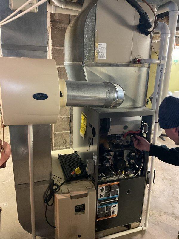 Conducted comprehensive inspection of aging furnace system in basement utility area with visible wear on copper piping and associated ductwork. Observed significant deterioration on horizontal copper lines showing discoloration and potential water damage to surrounding concrete floor. Recommend complete system replacement due to age-related component failure and inefficient operation of current unit.