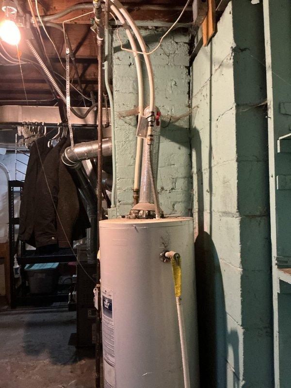 Performed standard furnace tune-up service as requested by customer. Inspected water heater system located in basement utility room against cinder block wall. System appears to be functioning normally with proper connections to copper pipes, gas line, and pressure relief valve. No immediate issues requiring attention were identified during the service visit.