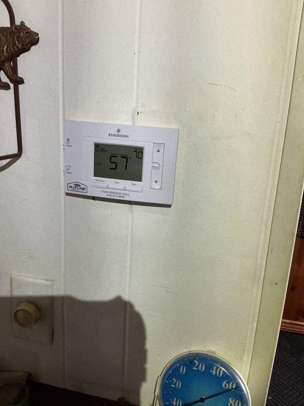 Responded to service call for furnace not heating. Diagnosed faulty blower motor causing system failure. Replaced motor assembly and capacitor, restoring proper operation. System now maintaining proper temperature with thermostat reading 57° against setpoint of 70° as heating cycle begins.