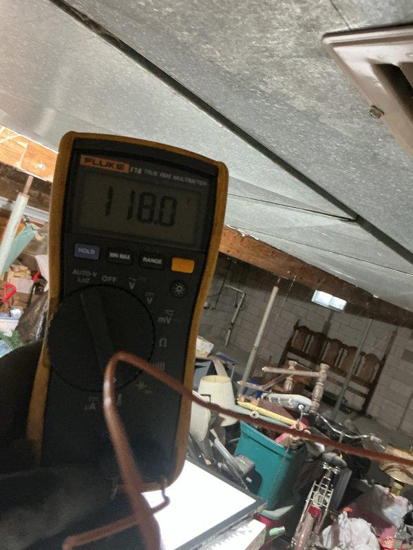 Performed maintenance on 4-year-old furnace. Conducted electrical inspection with multimeter, verifying proper voltage at 118.0V. Observed plumbing components and drainage system in utility area; noted concrete wall crack near HVAC installation.