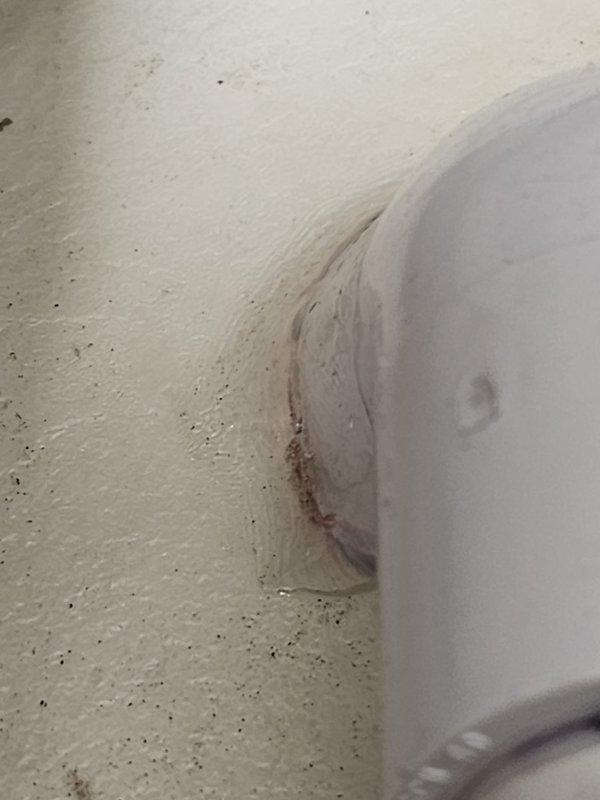 Completed install call back service by drilling drainage hole through floor for water heater drain pan and installed S40 room sensor for thermostat system. Documented existing water damage at fixture-wall junction that requires attention.