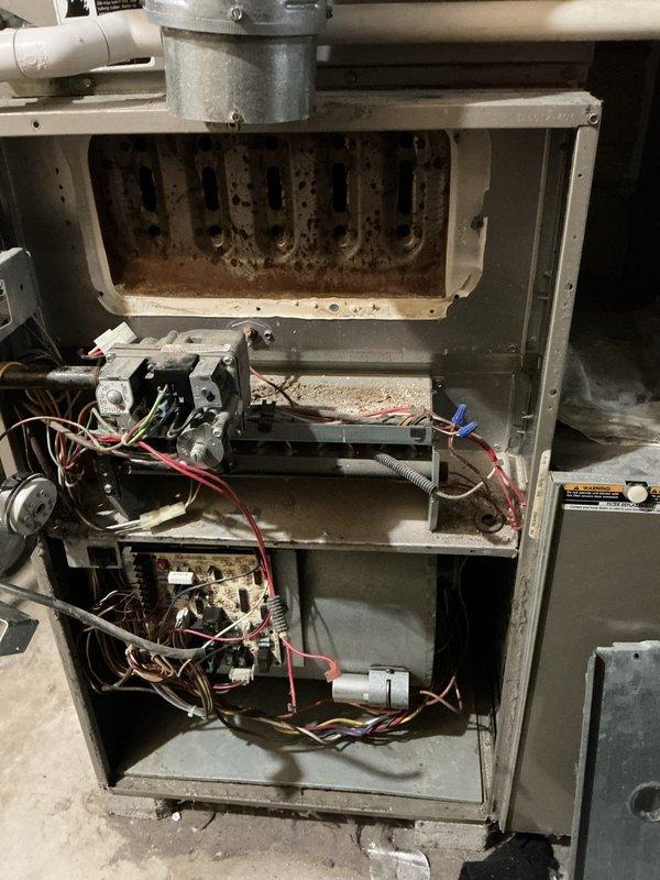 Responded to service call for natural gas furnace repeatedly shutting off. Inspection revealed significant dust and debris accumulation in heat exchanger and disorganized wiring throughout the system. Serviced blower motor component and documented furnace condition with photos for property manager's approval before proceeding with further repairs.