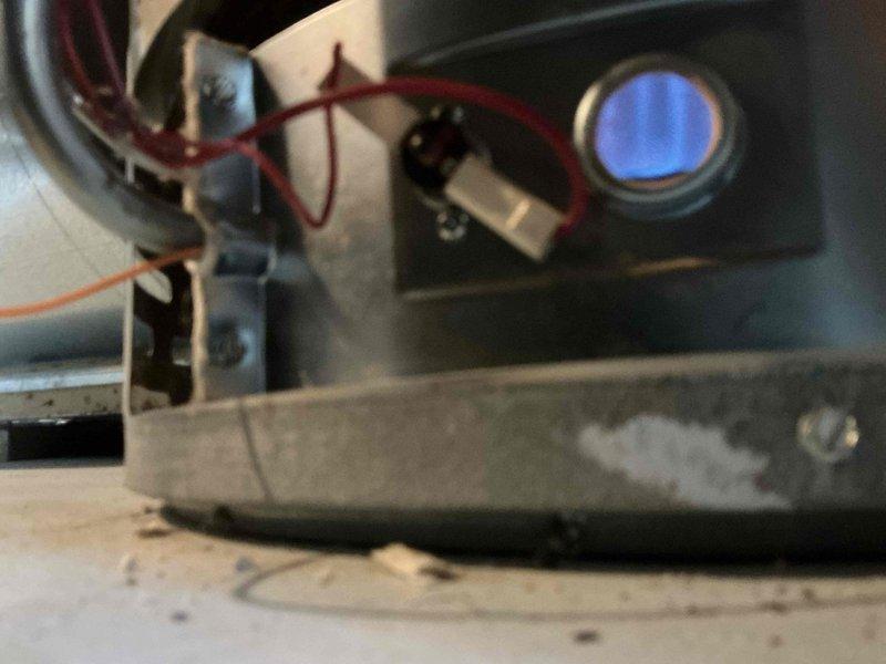 Responded to service call for water heater failing to maintain flame. Inspected unit and found visible blue flame through viewing port after repair. Serviced control panel components including temperature dial and gas connections, restoring proper ignition and operation of the tanked water heater.