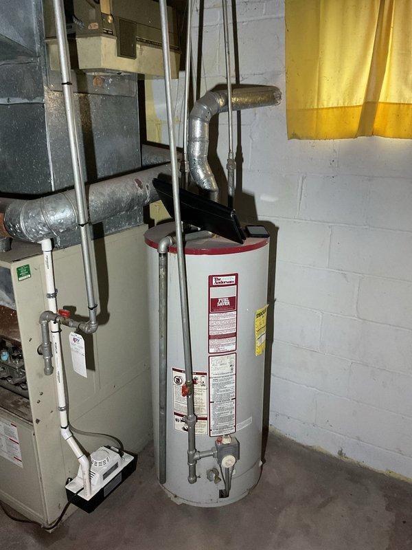 Conducted comprehensive assessment of existing HVAC system in basement utility area, including furnace unit with connected ductwork, air handler, and adjacent water heater system. Provided detailed replacement estimate for upgrading the aging furnace system, noting the current installation's configuration with metal plenum, 90-degree ductwork bends, and integration with existing water heating infrastructure.