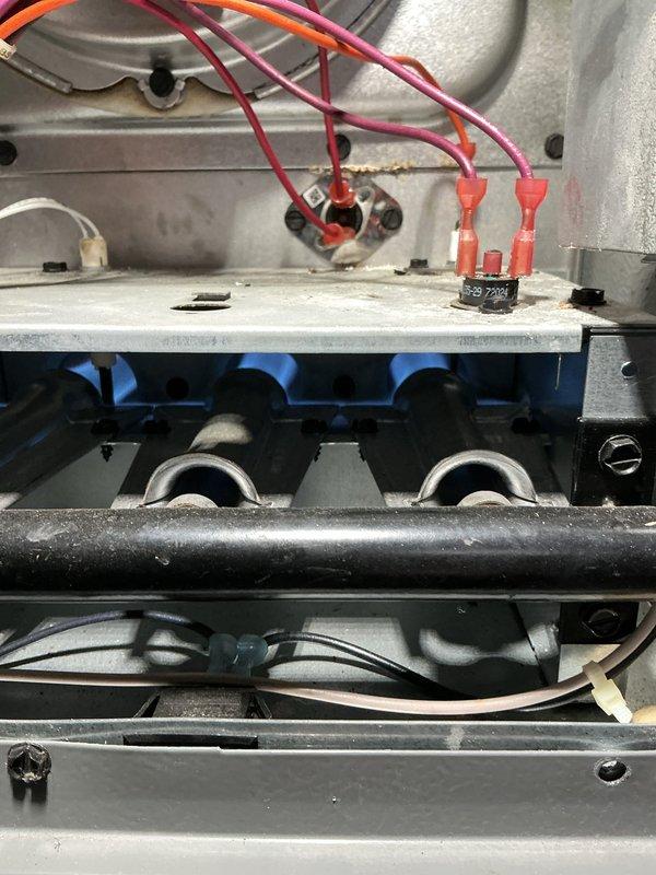 Responded to emergency service call for non-functioning blower in a 2-3 year old furnace. Inspected electrical connections at the control board, finding properly terminated wiring with red connectors. Observed operational gas burners with characteristic blue flame, indicating proper combustion. Verified ductwork integrity and airflow path was unobstructed with no visible damage to the ventilation system.