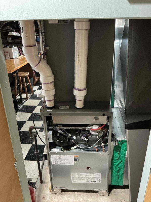 Performed comprehensive maintenance tune-up on residential furnace system located in utility area. Inspected all components including PVC ventilation/drainage pipes, electrical connections, and control elements. System is functioning properly with no issues identified during the preventive maintenance service.