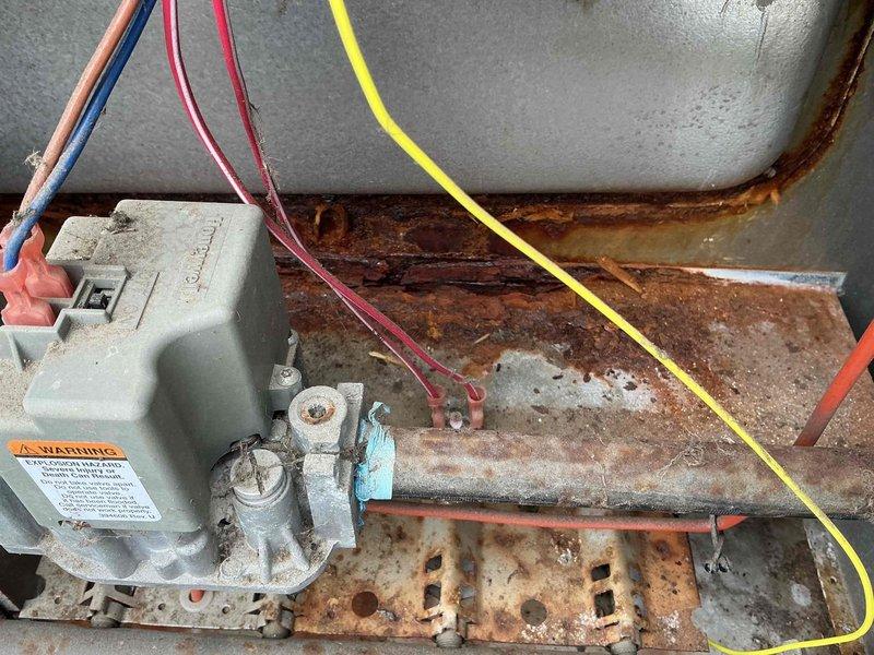 Diagnosed 15-year-old heat pump system with no heat complaint; inspection revealed severe corrosion on the indoor coil and heat exchanger components. System was short-cycling due to failed defrost board and deteriorated reversing valve, preventing proper heat mode operation. Replaced defrost control board, cleaned accessible components, and restored heating functionality with recommendation for full system replacement due to extensive age-related deterioration and inefficiency.